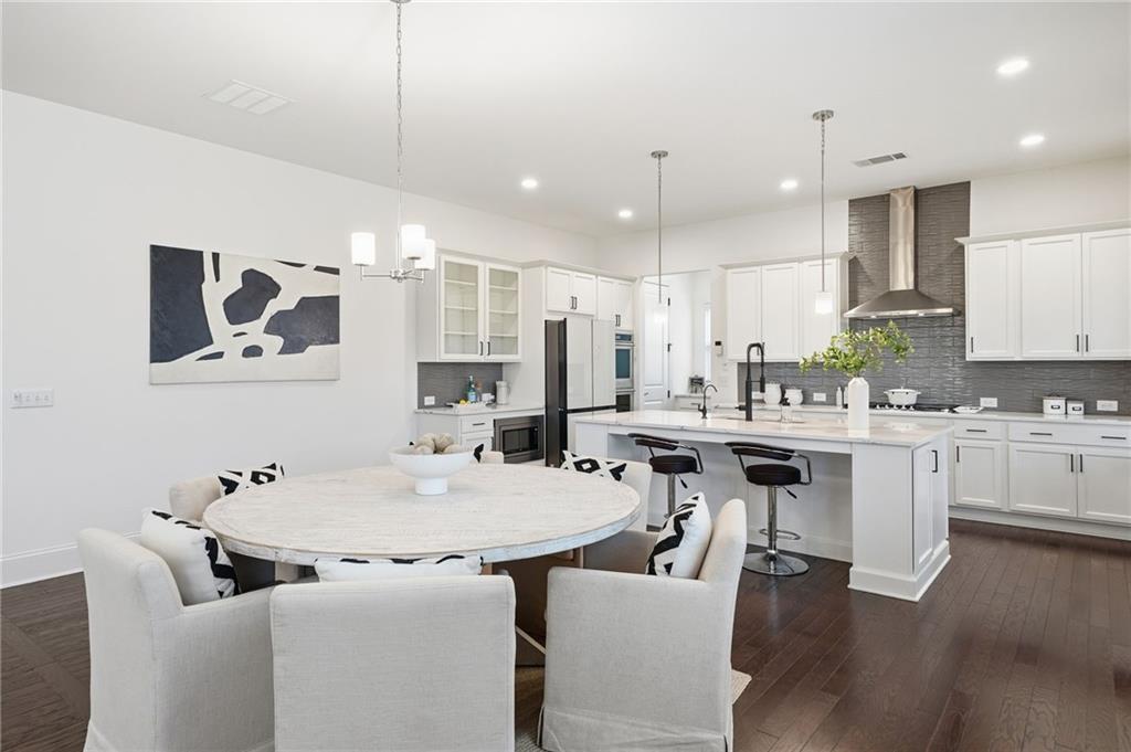 3180 Andover Street Cumming, GA 30028 - Photo 11 of 41 a kitchen with kitchen island granite countertop a sink and white appliances