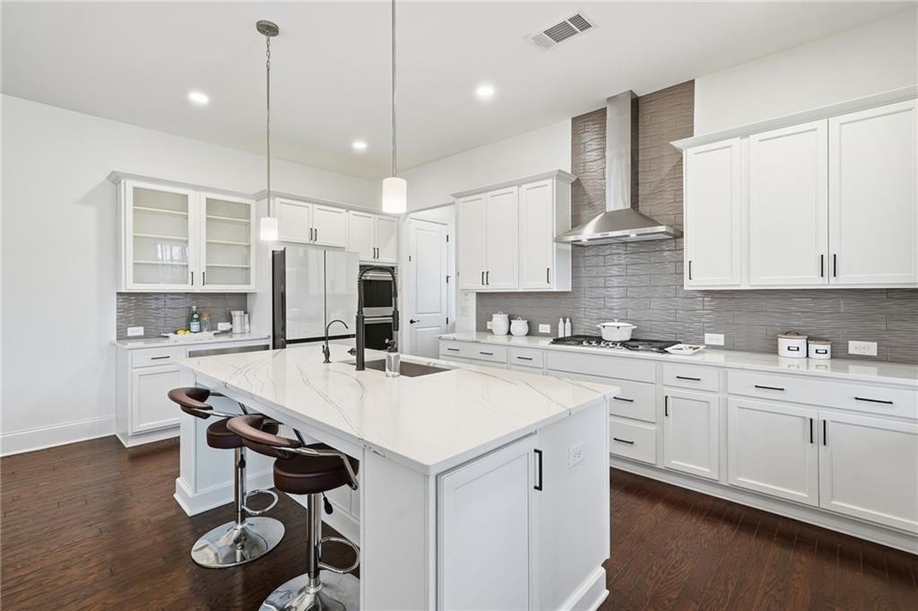 3180 Andover Street Cumming, GA 30028 - Photo 12 of 41 a kitchen with a sink a center island stainless steel appliances and cabinets