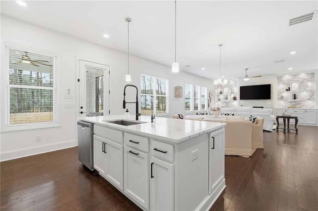 3180 Andover Street Cumming, GA 30028 - Photo 13 of 41 a large kitchen with cabinets a sink a stove and wooden floors