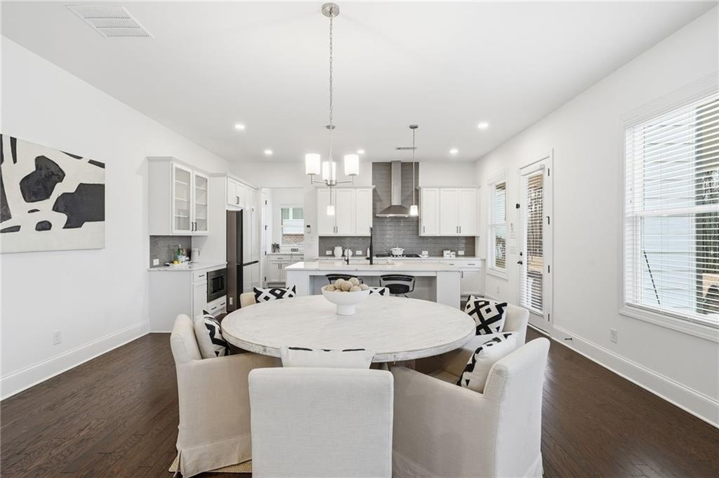 3180 Andover Street Cumming, GA 30028 - Photo 14 of 41 a large kitchen with kitchen island a stove a table and chairs in it