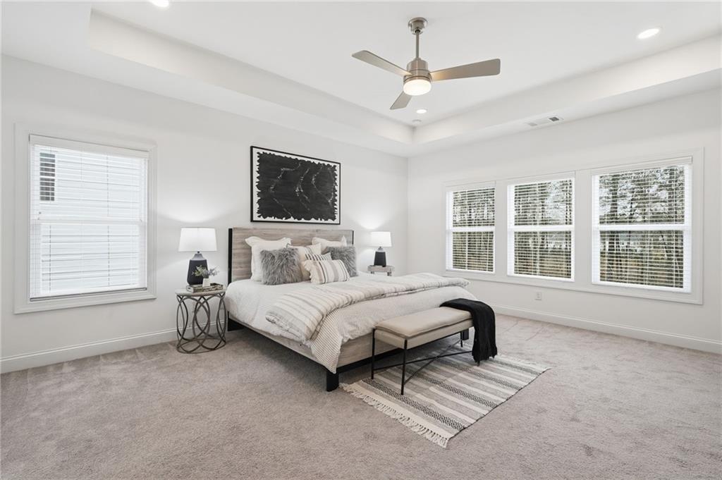 3180 Andover Street Cumming, GA 30028 - Photo 22 of 41 a spacious bedroom with a bed a window and a chandelier