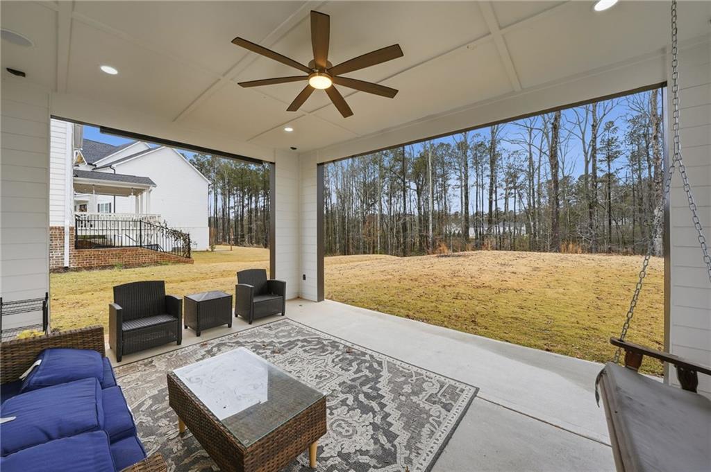 3180 Andover Street Cumming, GA 30028 - Photo 31 of 41 a living room with couch floor to ceiling window and a flat screen tv