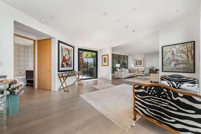a living room with furniture large window and wooden floor