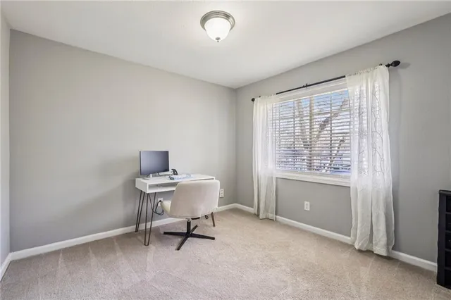 a view of a workspace with furniture and a window