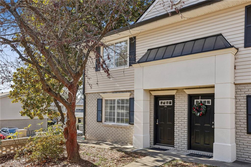 6940 Roswell Road, Unit A21 Atlanta, GA 30328 - Photo 2 of 25 a front view of a house with a tree