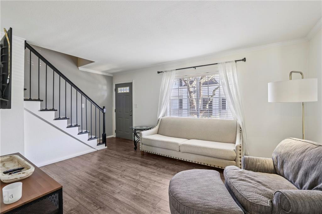 6940 Roswell Road, Unit A21 Atlanta, GA 30328 - Photo 5 of 25 a living room with furniture and a wooden floor
