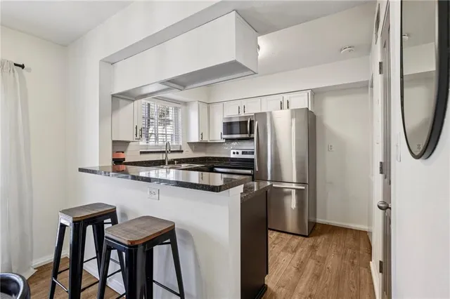 a kitchen with stainless steel appliances a refrigerator and a stove top oven