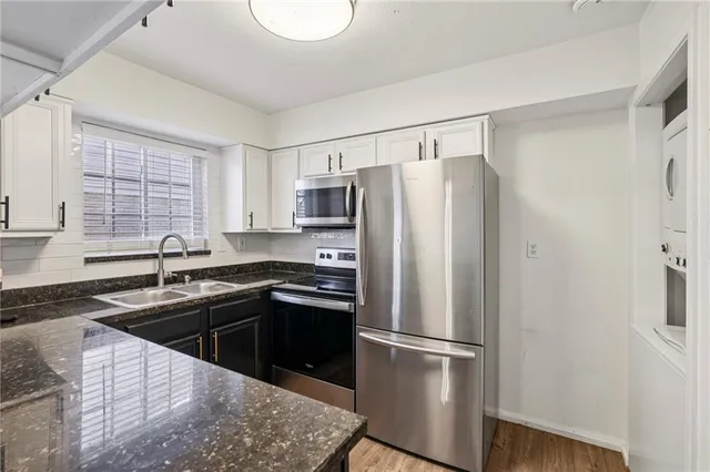 a kitchen with stainless steel appliances granite countertop a refrigerator a sink a stove a microwave and island