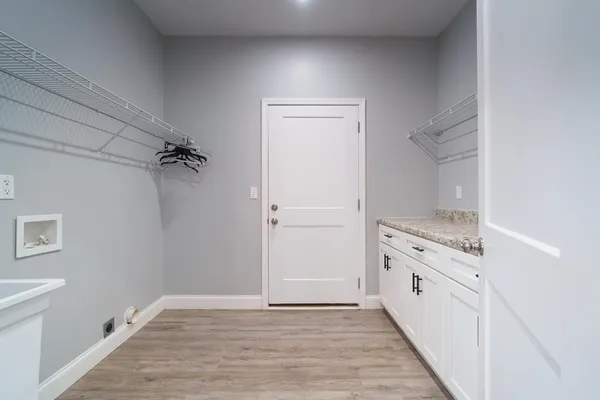 a view of a kitchen with white cabinets and wooden floor