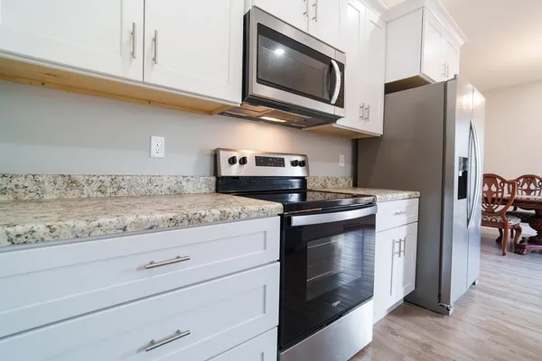 a kitchen with stainless steel appliances granite countertop a stove microwave and refrigerator