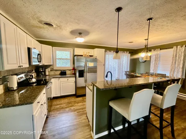 a kitchen with stainless steel appliances granite countertop sink stove top oven and refrigerator