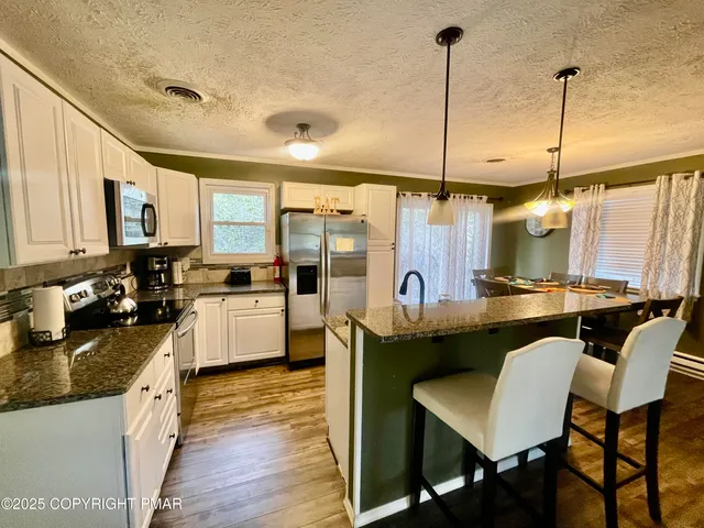a kitchen with stainless steel appliances granite countertop sink stove top oven and refrigerator