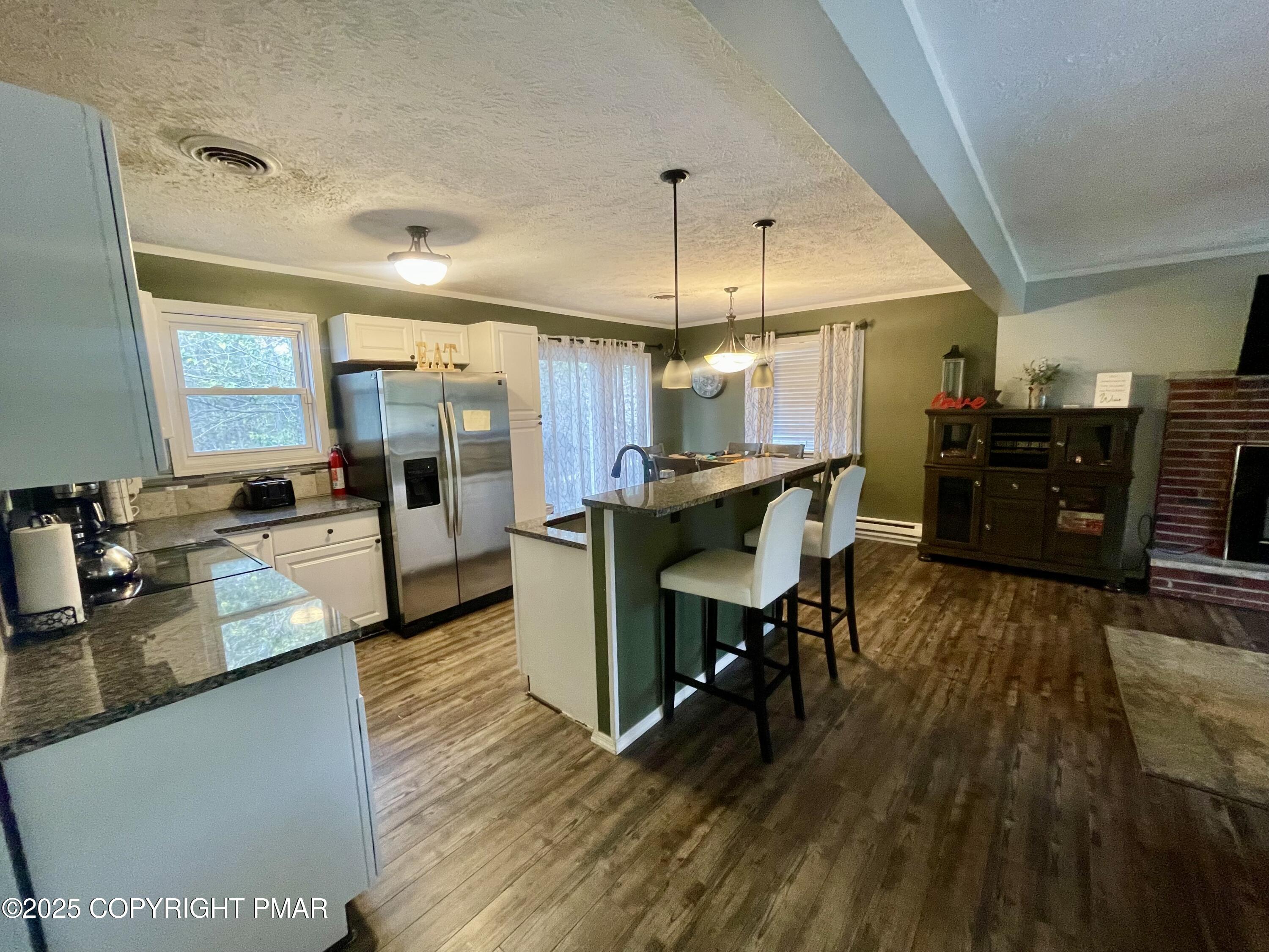 674 Country Pl Drive Tobyhanna, PA 18466 - Photo 3 of 17 a kitchen with stainless steel appliances kitchen island granite countertop a stove a refrigerator a sink a dining table and chairs with wooden floor