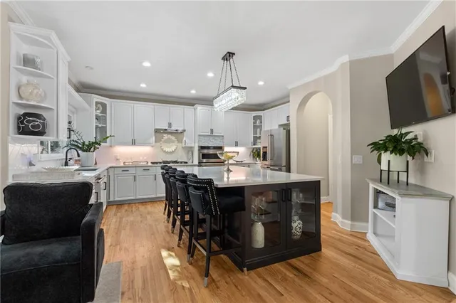 a kitchen with stainless steel appliances a stove a sink and white cabinets