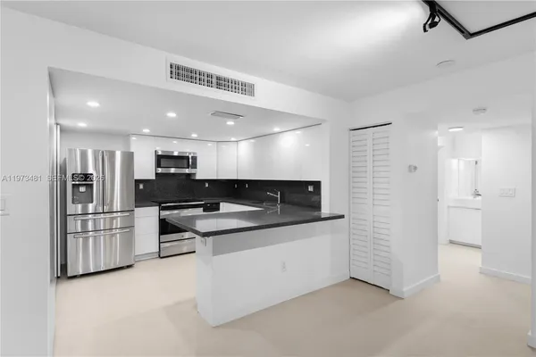 a kitchen with stainless steel appliances kitchen island sink stove and refrigerator