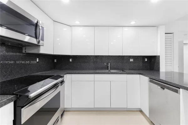 a view of cabinets a counter top space and stainless steel appliances