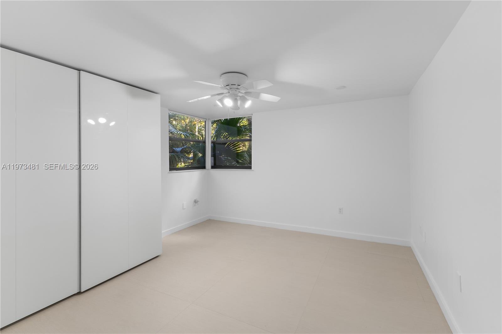 101 Ocean Ln Drive, Unit 1012 Key Biscayne, FL 33149 - Photo 17 of 39 an empty room with a chandelier fan and windows
