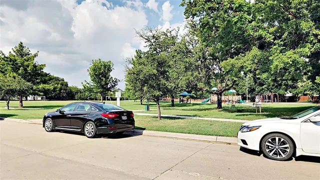 a car parked in front of a house with a big yard