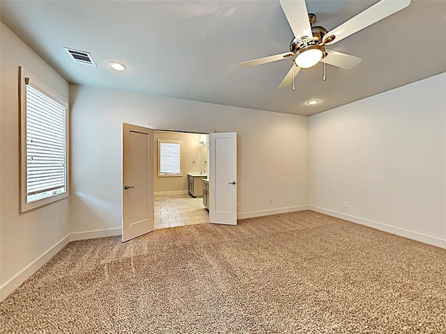 an empty room with fan and windows