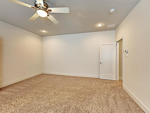 an empty room with a ceiling fan and a window