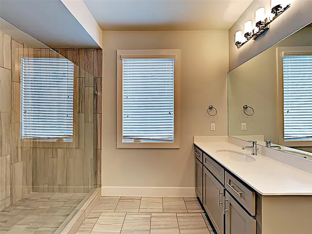 a bathroom with a sink a mirror and a shower