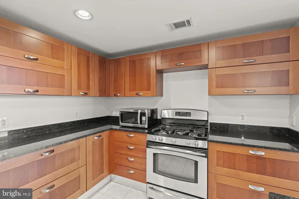 a kitchen with stainless steel appliances granite countertop a sink a counter space and cabinets