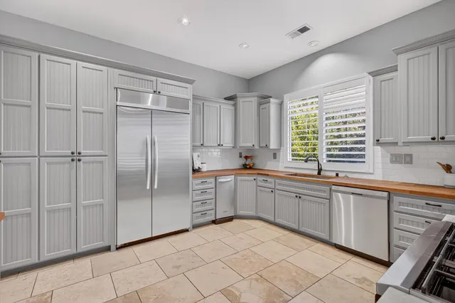 a kitchen with stainless steel appliances granite countertop a sink and a refrigerator