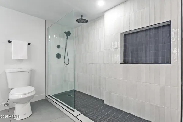 a bathroom with a toilet and a shower
