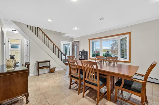 a dining room with furniture and entryway wooden floor and windows