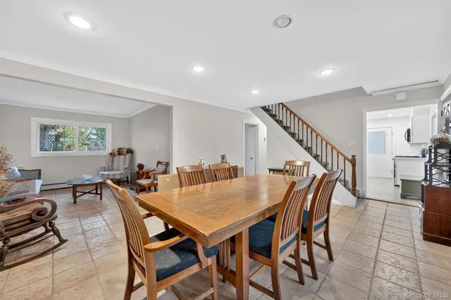 a view of a dining room and livingroom with furniture wooden floor and a rug