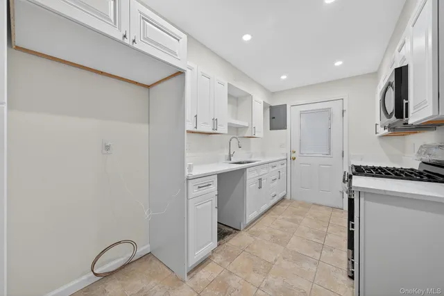 a kitchen with white cabinets and white appliances