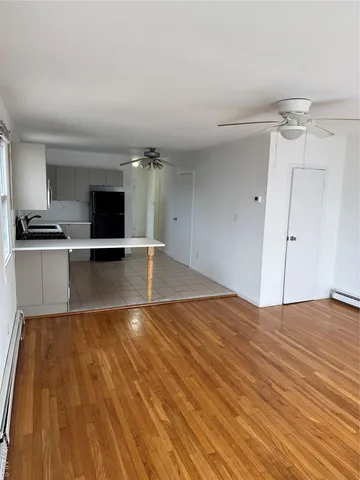 a view of empty room with wooden floor and fireplace