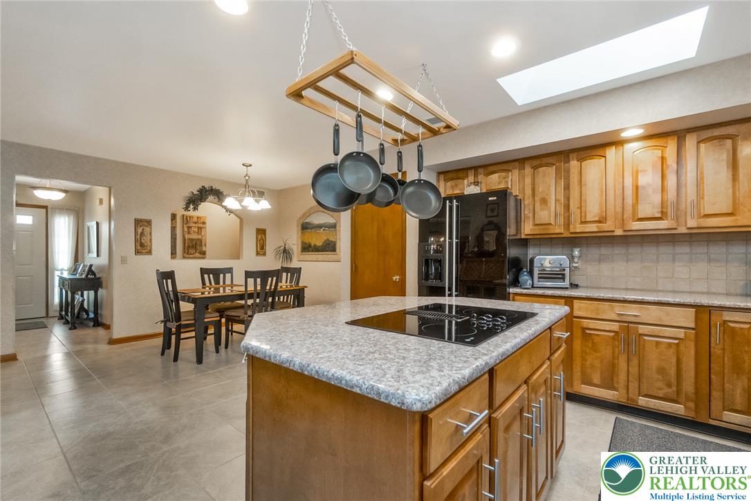2298 Yost Road Bath, PA 18014 - Photo 17 of 33 A well-equipped kitchen features a central island cooktop, ample cabinetry, and an adjoining dining space.