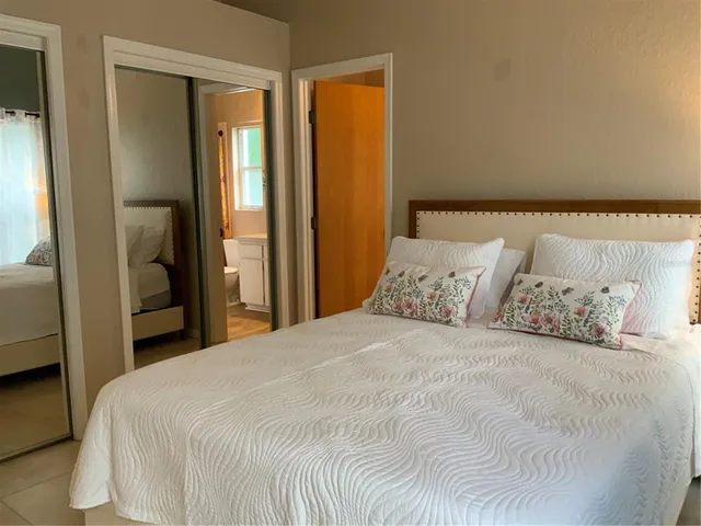 a large bed in a bedroom next to a window