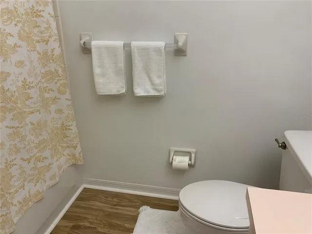 a white toilet sitting next to a shower