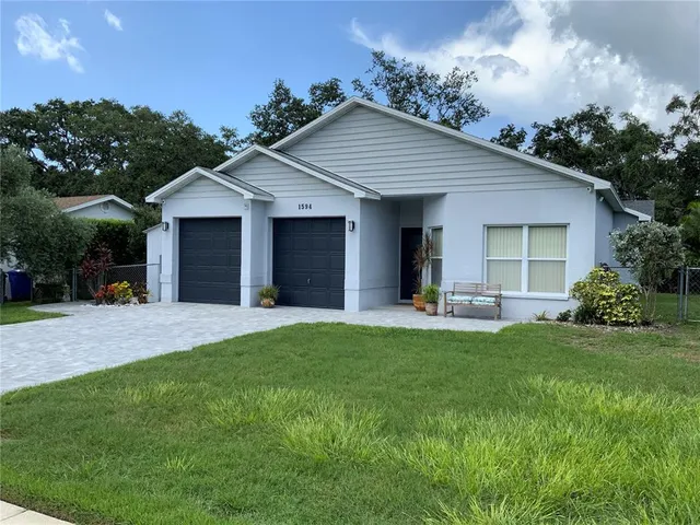 a view of a house with a yard and potted plants