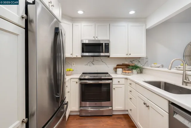 a kitchen with white cabinets stainless steel appliances and a sink
