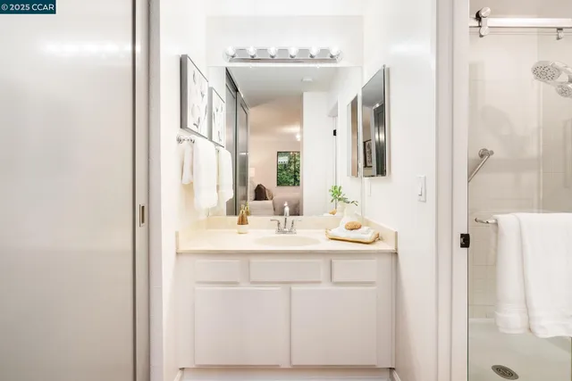 a bathroom with a double vanity sink mirror and shower