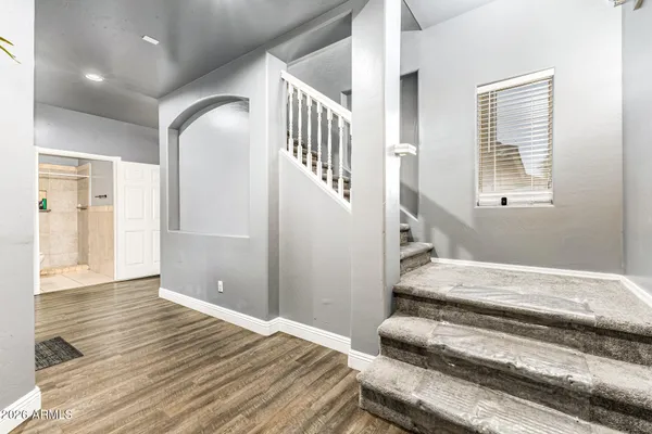 a view of a hallway with wooden floor and staircase