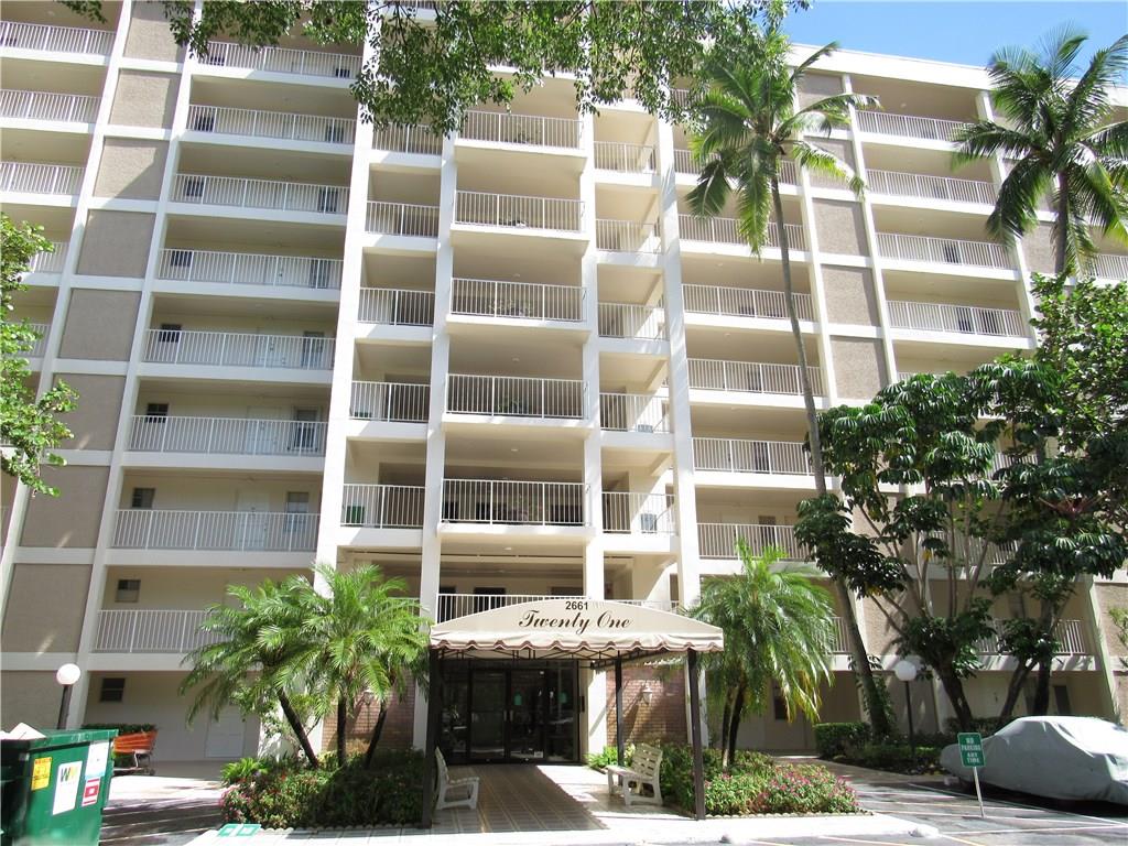 2661 South Course Drive, Unit 404 Pompano Beach, FL 33069 - Photo 16 of 16 a front view of a multi story building with a yard