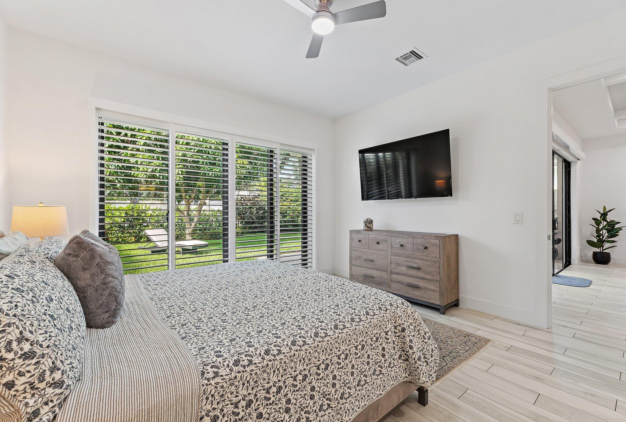 2908 Gin Berry Way West Palm Beach, FL 33401 - Photo 19 of 70 a bed room with a bed a television and a large window