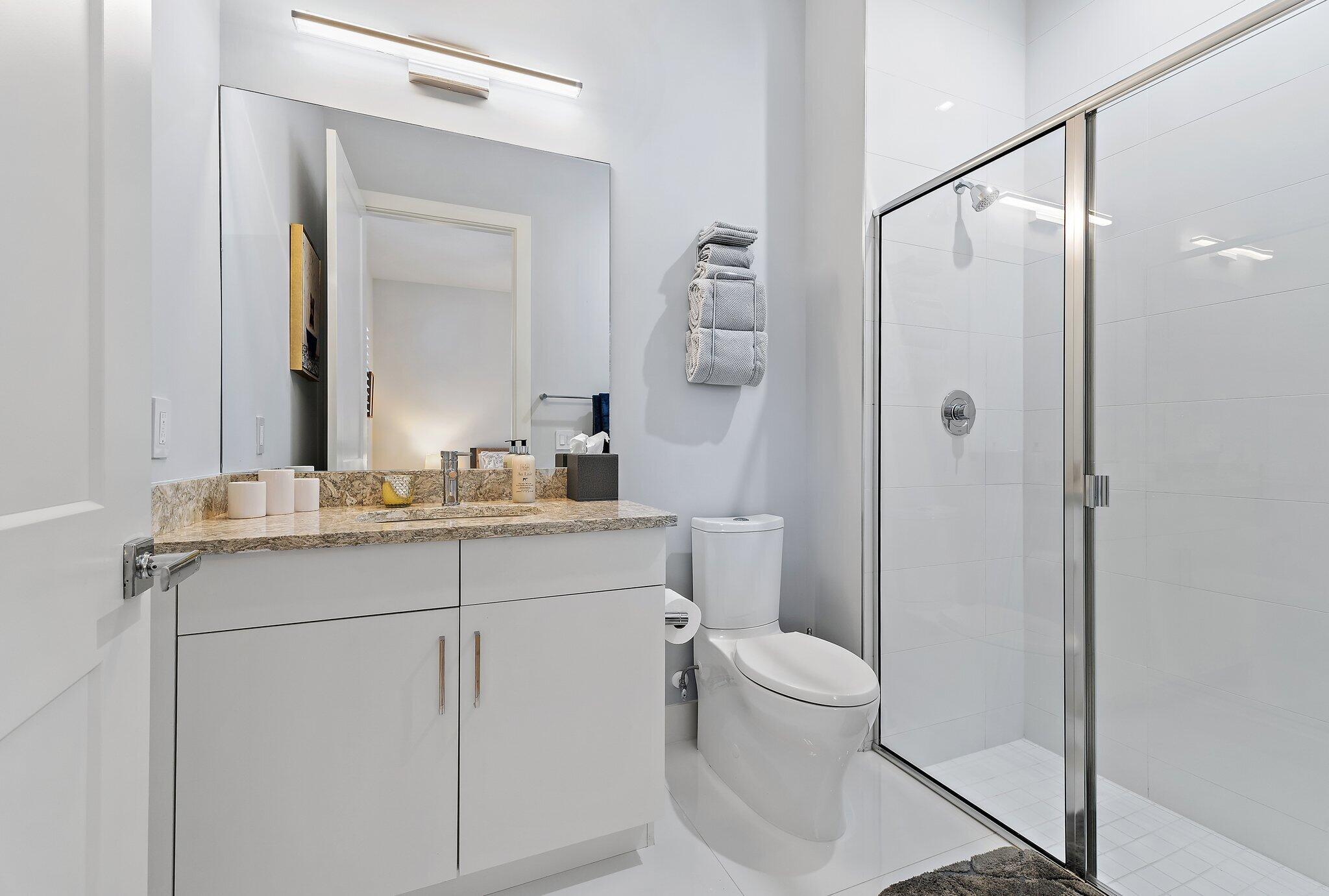 2908 Gin Berry Way West Palm Beach, FL 33401 - Photo 29 of 70 a bathroom with a granite countertop sink a toilet and a mirror