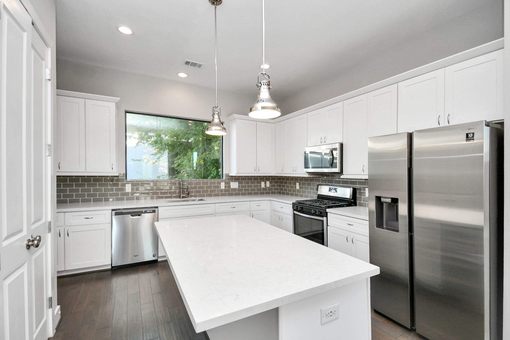 308 Palmer Street Houston, TX 77003 - Photo 10 of 36 a kitchen with a refrigerator a sink a center island and wooden floor
