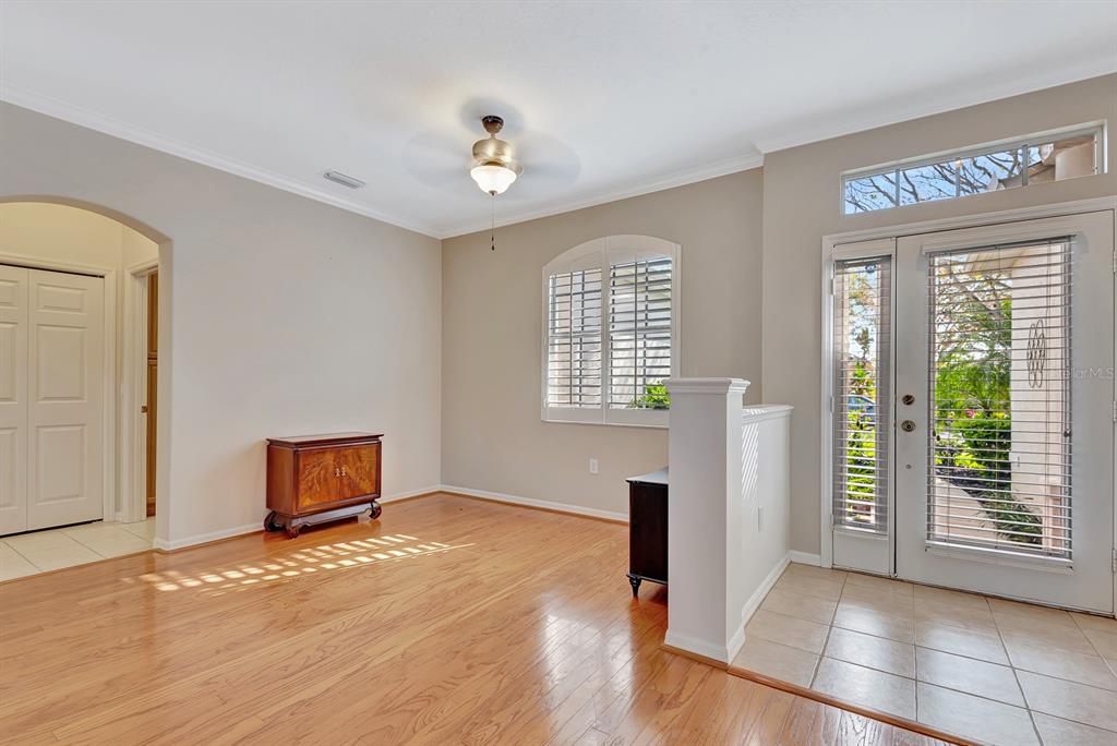 7344 Arrowhead Run Lakewood Ranch, FL 34202 - Photo 3 of 24 a view of an empty room with glass door and wooden floor