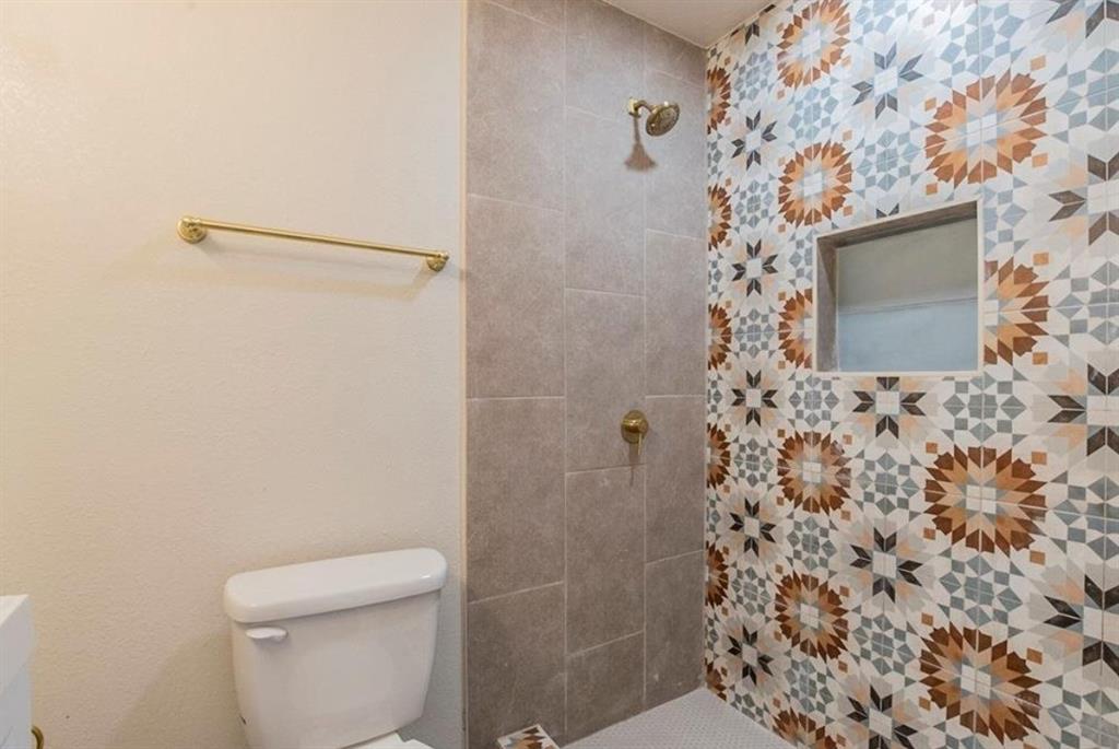 1821 East Grauwyler Road, Unit 188 Irving, TX 75061 - Photo 11 of 20 Shower with decorative tile wall, built-in niche, and brass fixtures