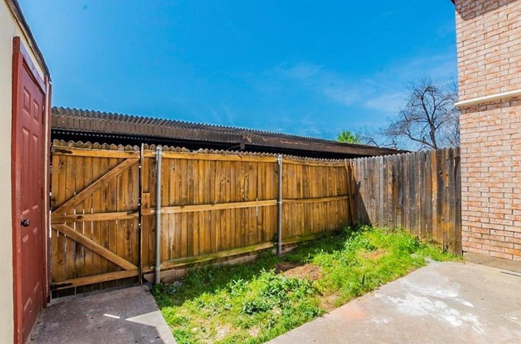 1821 East Grauwyler Road, Unit 188 Irving, TX 75061 - Photo 14 of 20 Private fenced yard featuring a wooden fence with gate, concrete patio, and brick exterior