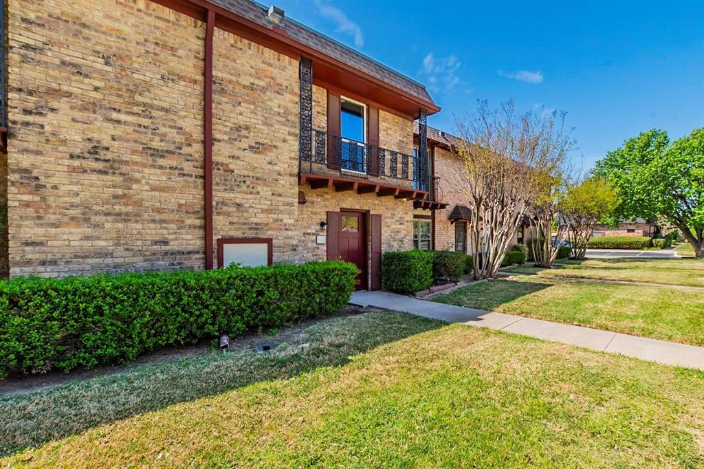 1821 East Grauwyler Road, Unit 188 Irving, TX 75061 - Photo 18 of 20 Brick exterior featuring a dark wood front door and second-story balcony with wrought iron railing