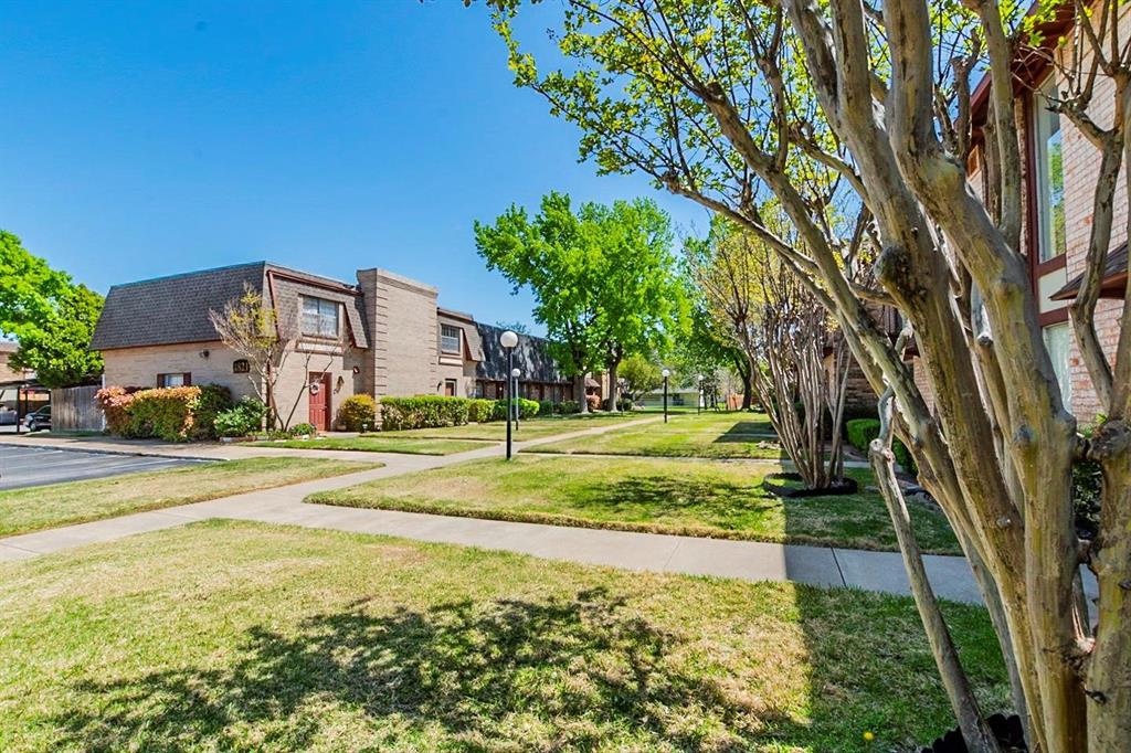 1821 East Grauwyler Road, Unit 188 Irving, TX 75061 - Photo 19 of 20 Brick exterior townhomes featuring a sloped roofline and mature landscaping