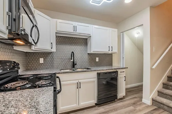 a kitchen with stainless steel appliances granite countertop a sink stove and cabinets