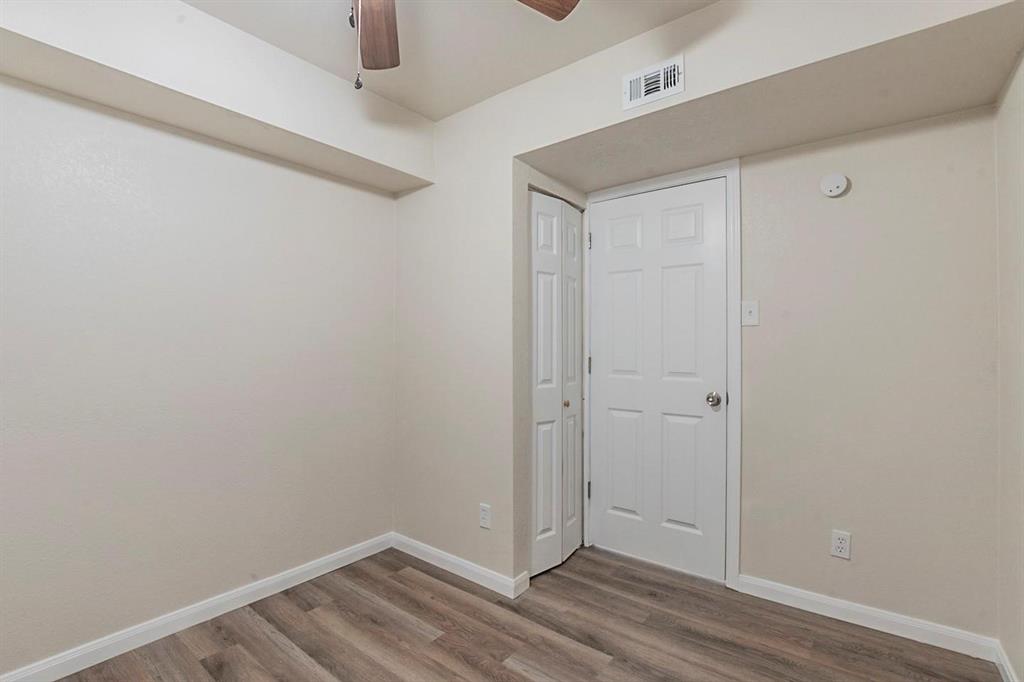 1821 East Grauwyler Road, Unit 188 Irving, TX 75061 - Photo 7 of 20 Room featuring wood-finish flooring, a white paneled door, and a bi-fold closet door